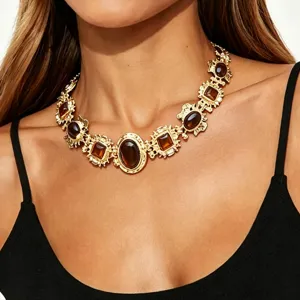 Collier statement baroque en résine dorée en détail, travail vintage et pierres élégantes.