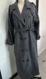Vue détaillée du trench-coat long gris foncé en laine avec revers et boutons croisés.