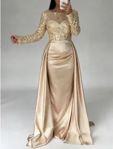 Elegant gold sequin long sleeve evening dress with satin drape skirt for formal events.