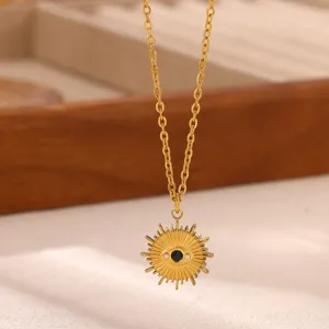 Close-up detail shot of a gold plated evil eye sunburst pendant necklace with a dark center stone.