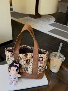 Canvas plaid cosmetic bag with cute cartoon girl print, brown suede handles and plush pendant.