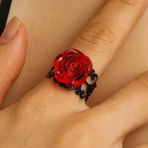Detailed view of a fashionable red resin rose ring featuring a delicate black metal band.