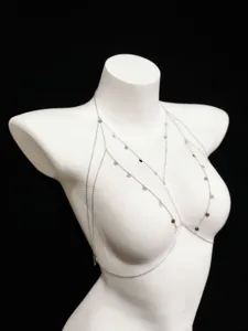 Detailed close-up view of silver multi-layered body chain featuring shiny coin pendants.