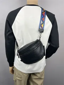 Black leather crossbody bag for men with colorful geometric wide strap and zipper pockets.
