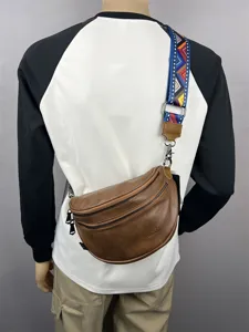 Detailed shot showing the brown leather crossbody bag worn across the body with a colorful strap.
