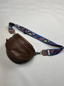 Detail view of brown PU leather crossbody bag featuring colorful geometric pattern wide strap.