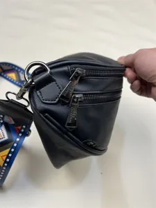 Black crossbody bag featuring colorful woven strap and double zipper hardware for daily casual use.