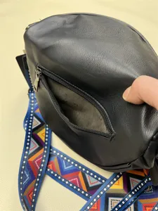 Black spherical crossbody bag with colorful woven strap, retro casual style, detail display.