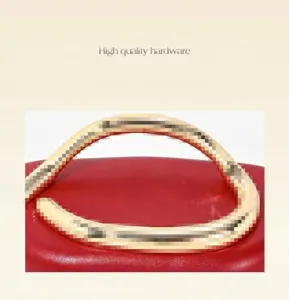 Detail view of luxury red evening bag featuring custom metallic handle design and fine craftsmanship.