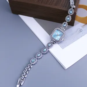 Silver rhinestone square quartz watch with blue crystal teardrop link bracelet for women.