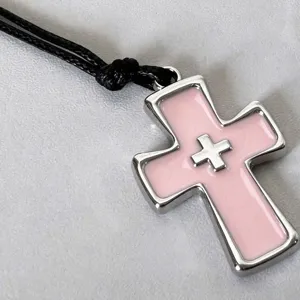Pink enamel cross pendant necklace detail, vintage y2k gothic style black cord jewelry.