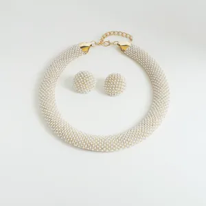 Close-up product detail shot featuring a chunky pearl statement necklace and matching earrings.