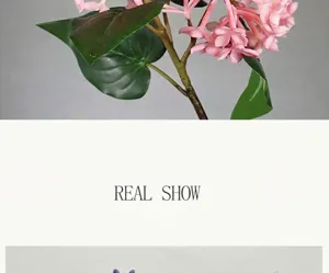 Artificial lilac flower stem detail, pink faux floral branch with green leaves decor.