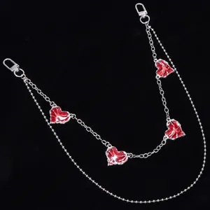 Close-up of punk style double-layered metal pants chain featuring red heart charms and clasps.