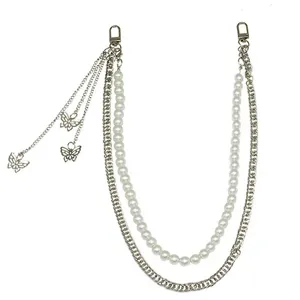 Detail shot of punk hip hop pearl metal pants chain with cute butterfly charms for streetwear.