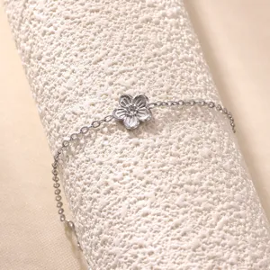 Primer plano detallado de una pulsera de flores con brillantes de pedreria en expositor texturizado.