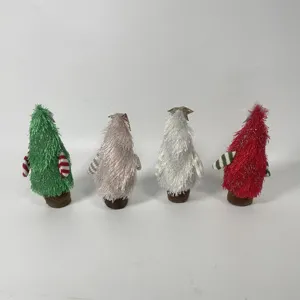 Nahaufnahme von niedlichen Plüsch-Weihnachtsbaum-Figuren als weiche Tischdekoration.