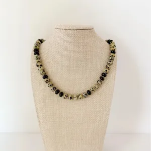 Chic collier en jaspe dalmatien et perles noires avec intercalaires dorés, détail bijoux.