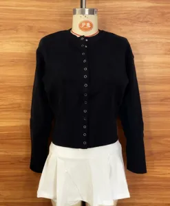 Cárdigan de punto negro de manga larga con botones y falda blanca vista detallada de moda.
