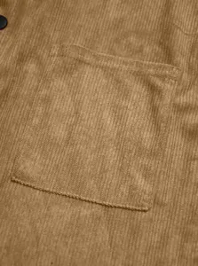 Vista dettagliata della camicia in velluto a coste da uomo con tasca strutturata e tessuto morbido.