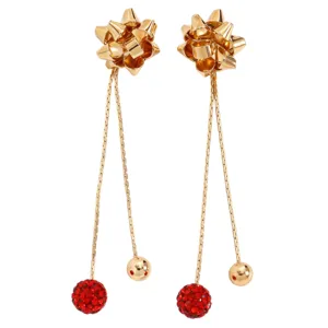Gold bow earrings detail, featuring red crystal ball and smooth gold ball long chain drops.