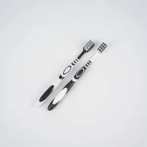 Adult toothbrush set with spiral bristles, ergonomic handle, black and white pair, clean.
