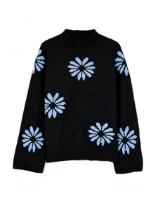 Detail view of black knit pullover sweater featuring light blue floral patterns and ribbed trim.