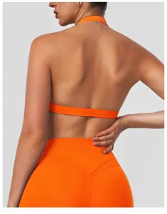 Detail view of backless orange halter sports bra and high-waisted yoga fitness outfit.