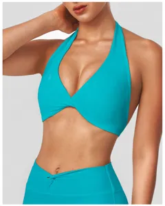 Close-up detail of turquoise halter yoga bra top featuring stylish front twist design.