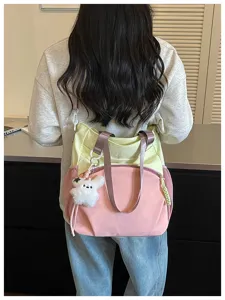 Vue de dos montrant un sac jaune et rose avec un porte-clés lapin en peluche au bureau