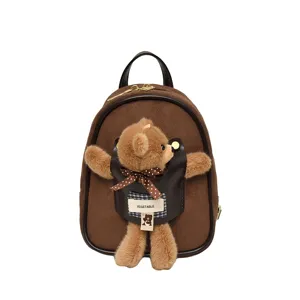 Small brown suede backpack with a plush teddy bear charm, black trim, and gold-tone hardware
