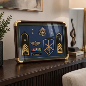 Display of U.S. Army rank insignia, medals and ribbons on a navy backing in a gold-trimmed frame
