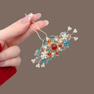 Chinese-style gold hairpin with blue enamel, red beads, pearls and white flowers, shown in hand