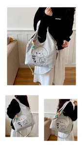 Sac gris clair porté à l’épaule, avec motif de chien, sangle réglable et breloque colorée à perles