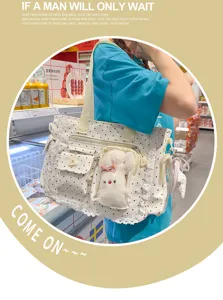 Sac à pois porté en magasin, avec dentelle et pochette transparente contenant un lapin en peluche