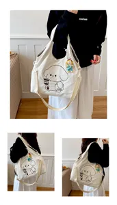 Trois vues d’un sac en toile crème porté à l’épaule, avec chien illustré et charm poupée coloré