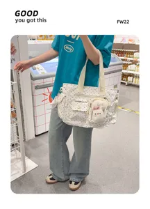 Le modèle porte un sac blanc à pois avec dentelle, des nœuds et une breloque lapin en peluche.
