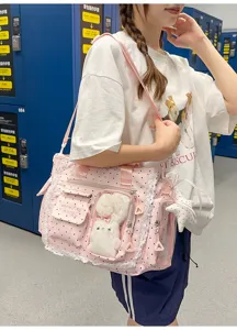 Un modèle porte un sac rose à pois, avec bordure en dentelle, poches transparentes et lapin en peluche