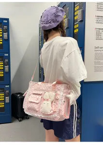 Vue de dos d’un modèle avec un sac rose à pois, dentelle et breloque lapin en peluche.