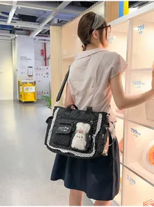 Vue de dos : sac noir à pois, dentelle blanche, fenêtre transparente et petit pendentif en peluche
