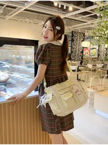 Femme portant un cabas beige à pois, avec dentelle et poche transparente dans un café