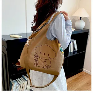 Vue d’un sac brun porté à l’épaule, avec un imprimé de chien cartoon et de tasse de café