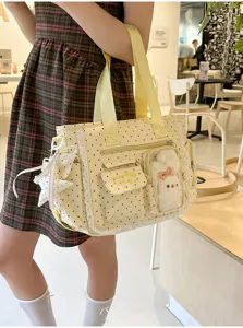 Vue du sac jaune pâle à pois, avec dentelle, poche transparente, ours en peluche et breloque étoile