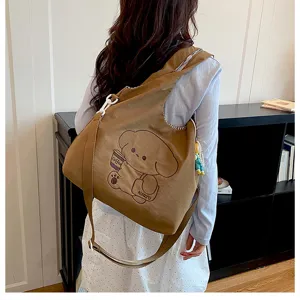 Vue de dos d’un modèle portant un sac beige avec un chien amateur de café et un bijou de perles