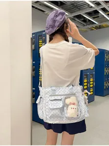 Sac cabas à pois bleu et blanc, dentelle et lapin en peluche, porté devant des casiers bleus