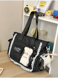 Gros plan sur un sac noir à pois, dentelle blanche, poche transparente et breloque étoile