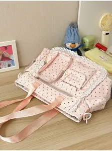Détail du tissu rose à pois, bordé de dentelle, avec plusieurs poches zippées et de larges anses