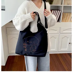 Vue d’un modèle portant un sac noir, orné d’un petit chien et d’une tasse de café