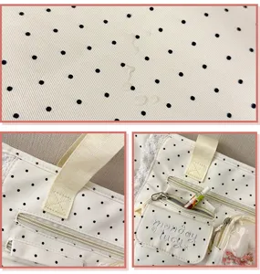 Détail du tissu blanc à pois noirs, avec poignée beige, poche zippée et petite pochette transparente