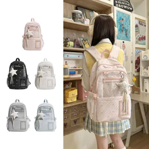 Cinq coloris de sacs à dos près d’une fille portant le modèle rose à étoiles dans sa chambre d’étude